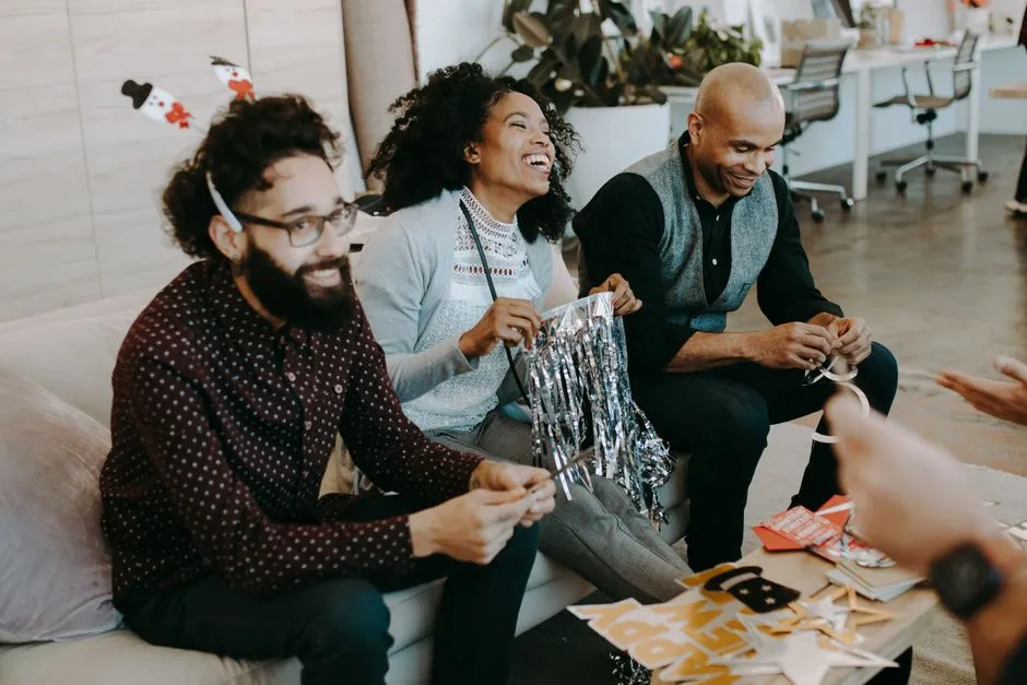 Colleagues enjoying crafts and laughter at a cheerful office party.
